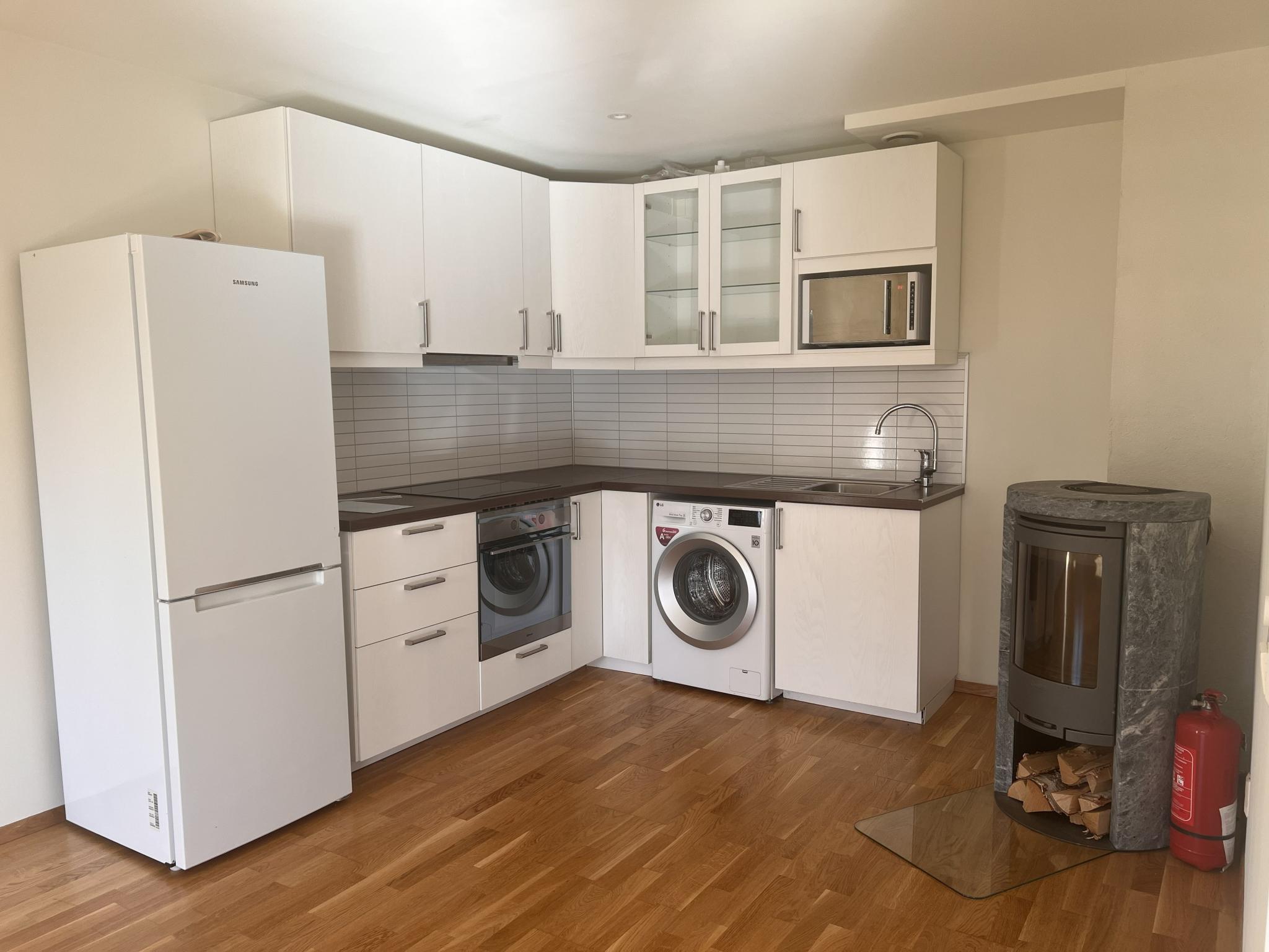 •	Kjøkken: Moderne, hvit innredning med integrerte hvitevarer (koketopp, stekeovn, ventilator, kjøl/frys, mikro og vaskemaskin).